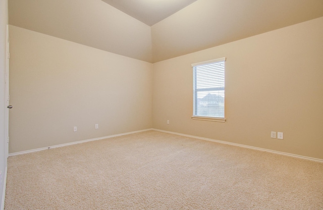 carpeted spare room featuring lofted ceiling