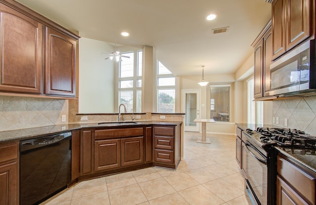 kitchen with sink, ceiling fan, appliances with stainless steel finishes, decorative light fixtures, and kitchen peninsula