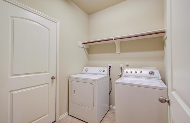 washroom featuring washer and clothes dryer and light tile patterned flooring