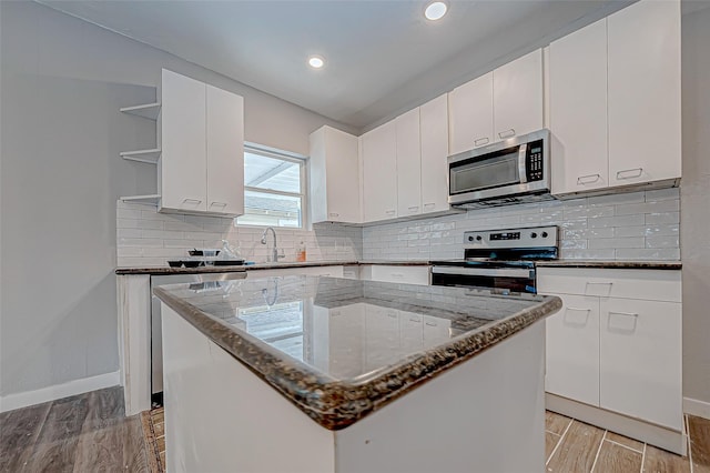 kitchen featuring stainless steel appliances, white cabinetry, a kitchen island, and light hardwood / wood-style flooring