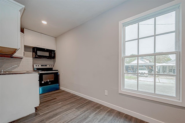 kitchen featuring white cabinets, range with electric stovetop, sink, and a wealth of natural light