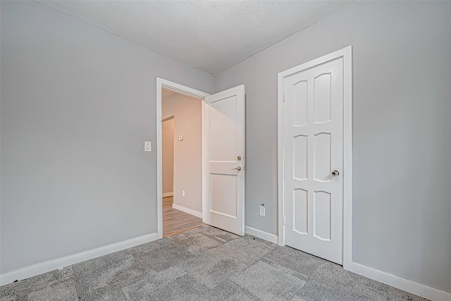 carpeted spare room with a textured ceiling