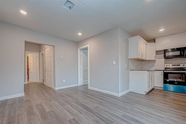 kitchen with backsplash, light hardwood / wood-style flooring, white cabinets, and stainless steel range oven