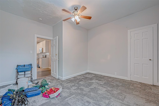 recreation room with ceiling fan, carpet floors, and a textured ceiling