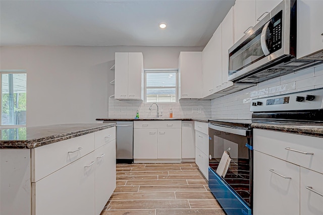 kitchen featuring white cabinets, appliances with stainless steel finishes, and sink