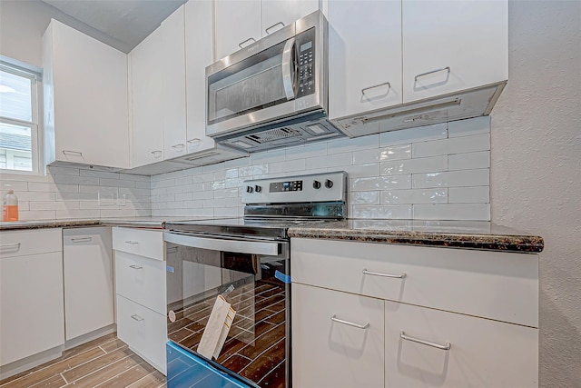 kitchen featuring tasteful backsplash, dark stone countertops, white cabinets, and stainless steel appliances