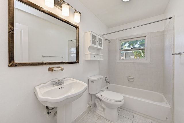 bathroom with tile patterned flooring, tiled shower / bath, and toilet