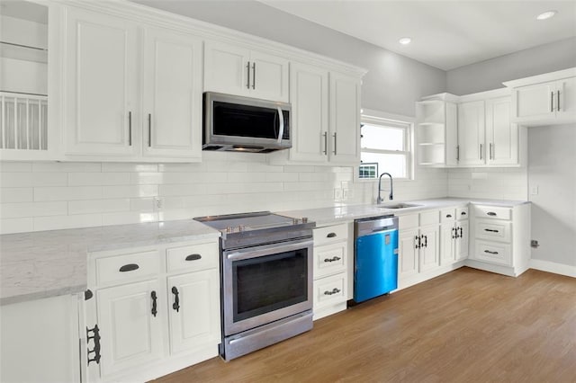 kitchen with white cabinetry, sink, stainless steel appliances, and light hardwood / wood-style flooring