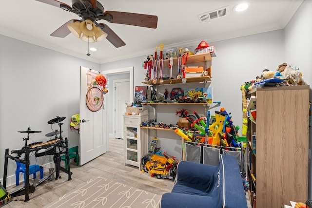 game room featuring crown molding, light hardwood / wood-style flooring, and ceiling fan