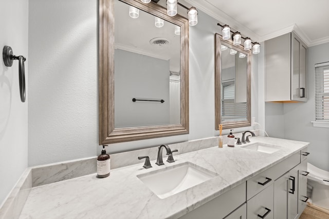 bathroom with ornamental molding, toilet, and vanity