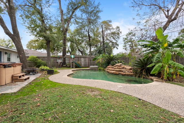 view of pool with a yard and a hot tub