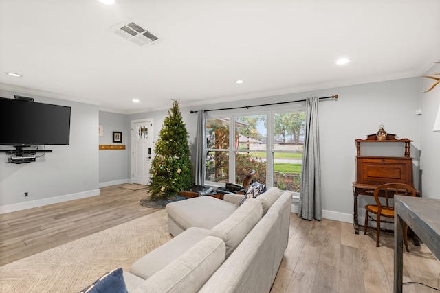 living room featuring ornamental molding and light hardwood / wood-style flooring