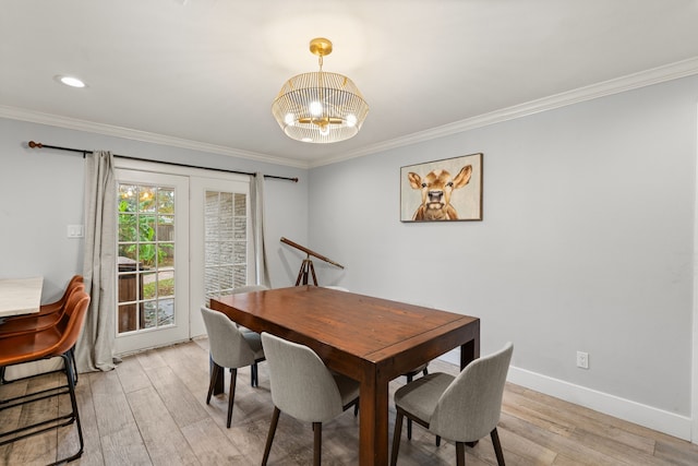 dining room featuring an inviting chandelier, ornamental molding, and light wood-type flooring