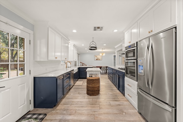 kitchen featuring pendant lighting, stainless steel fridge, plenty of natural light, white cabinets, and blue cabinets