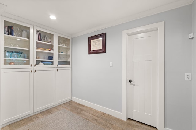 interior space with crown molding and light hardwood / wood-style flooring