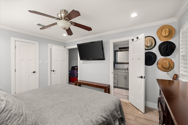 bedroom with crown molding, light hardwood / wood-style flooring, ceiling fan, and ensuite bathroom