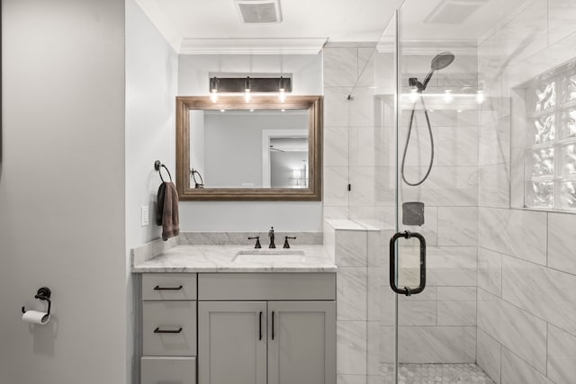 bathroom featuring ornamental molding, vanity, and walk in shower