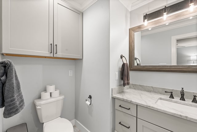 bathroom with vanity, crown molding, and toilet