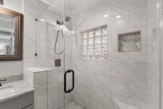 bathroom with a shower with door, vanity, and crown molding