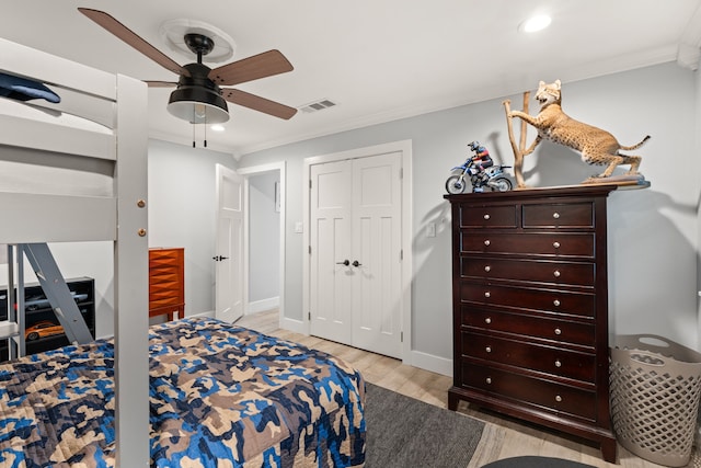 bedroom featuring crown molding, ceiling fan, light hardwood / wood-style floors, and a closet