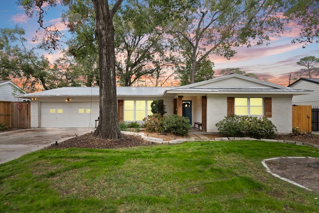 ranch-style home with a yard and a garage