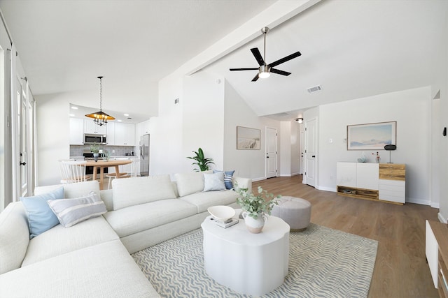 living room featuring ceiling fan, beamed ceiling, wood-type flooring, and high vaulted ceiling