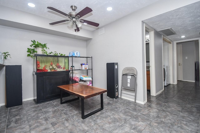 office area featuring ceiling fan, washer / dryer, and a textured ceiling