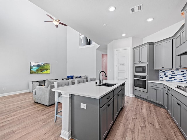 kitchen featuring stainless steel appliances, visible vents, a sink, and gray cabinetry