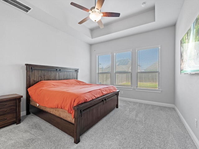 bedroom featuring baseboards, visible vents, a raised ceiling, and carpet flooring