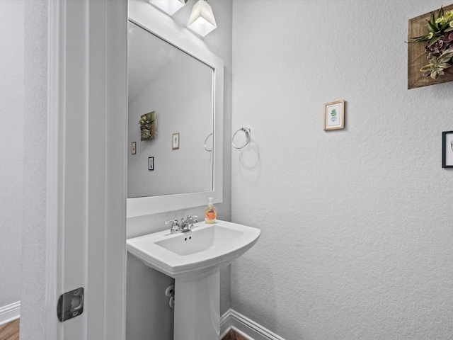 bathroom featuring a sink and a textured wall