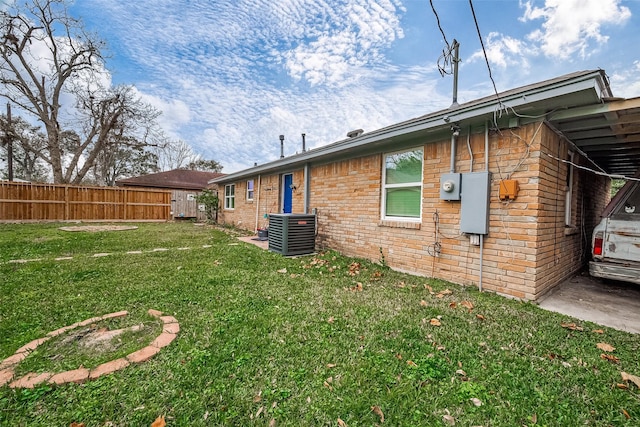 rear view of property featuring central AC and a yard