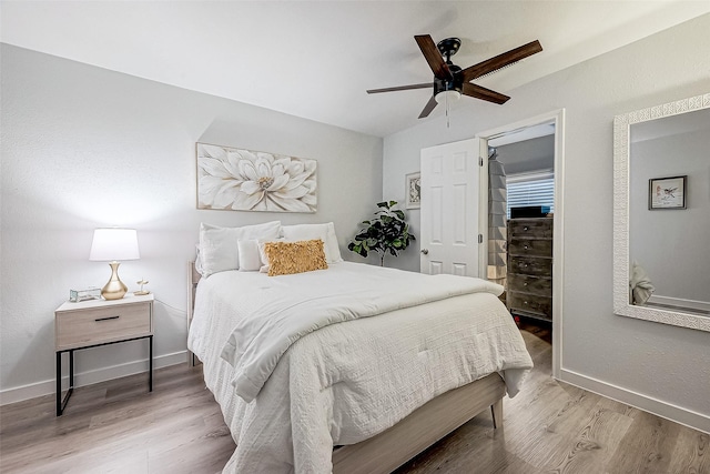 bedroom with ceiling fan, light wood-type flooring, and lofted ceiling