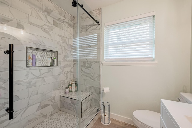 bathroom featuring hardwood / wood-style flooring, vanity, toilet, and a shower with door