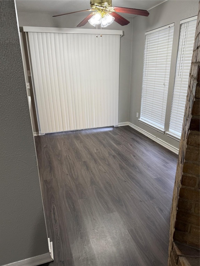 empty room with dark hardwood / wood-style floors and ceiling fan