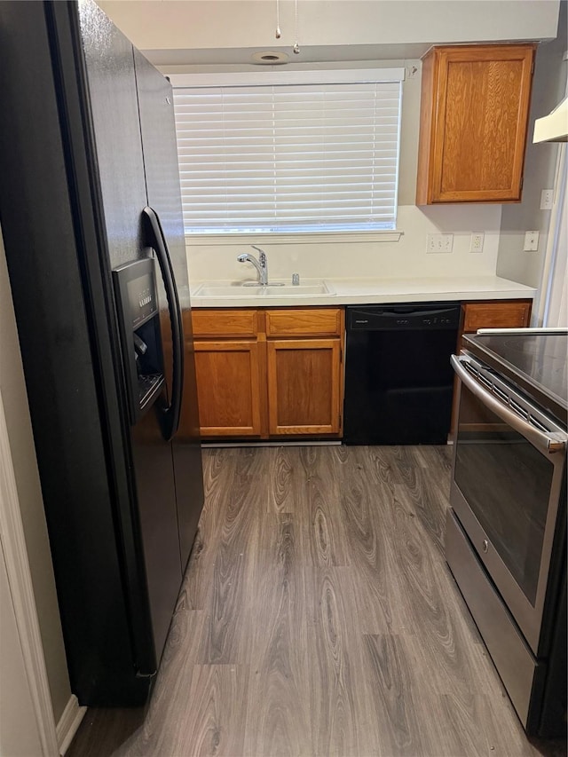 kitchen featuring fridge with ice dispenser, dishwasher, sink, dark hardwood / wood-style floors, and electric stove