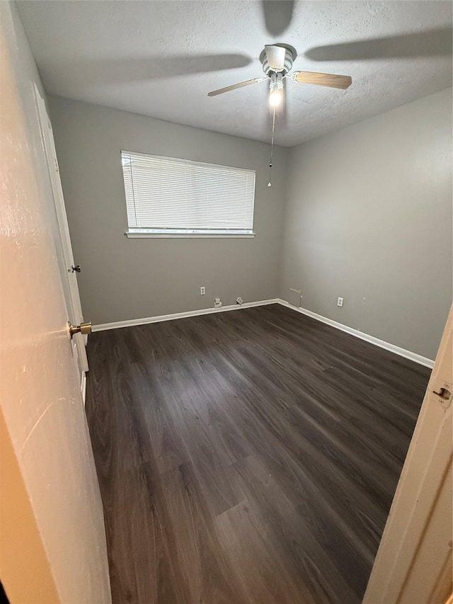 empty room featuring a textured ceiling, dark hardwood / wood-style floors, plenty of natural light, and ceiling fan