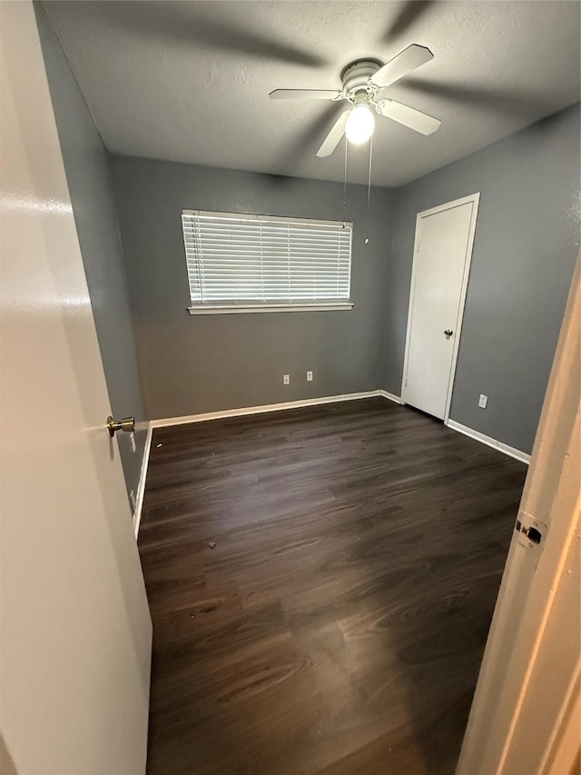 spare room with ceiling fan and dark hardwood / wood-style flooring