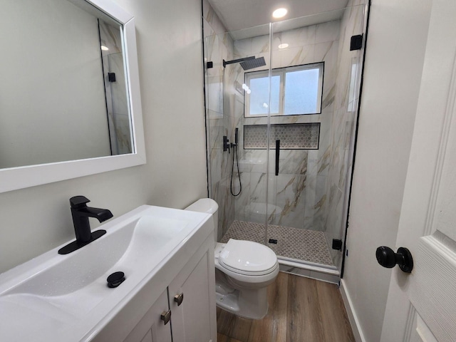 bathroom with vanity, hardwood / wood-style flooring, toilet, and a shower with shower door