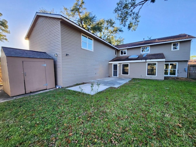 rear view of house with a yard, a patio, and a storage shed