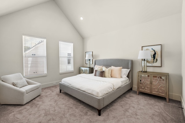 carpeted bedroom with high vaulted ceiling