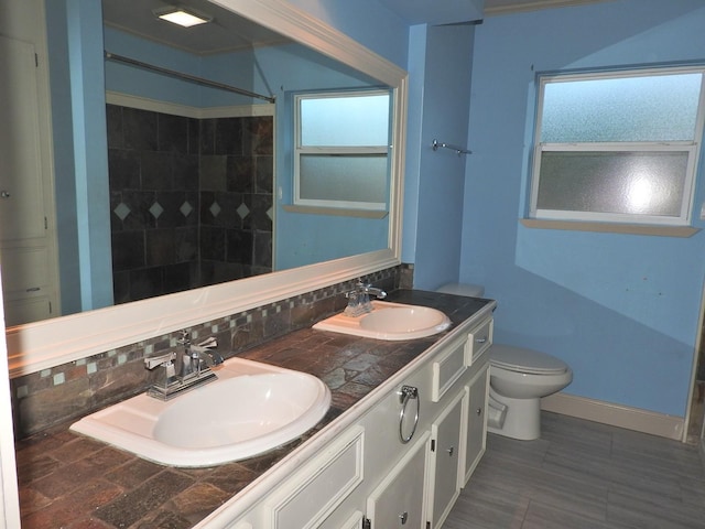 bathroom with vanity, backsplash, and toilet