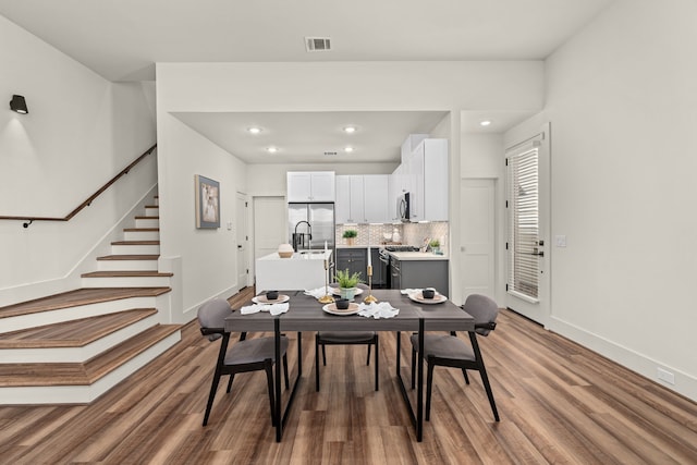 dining space featuring wood-type flooring and sink