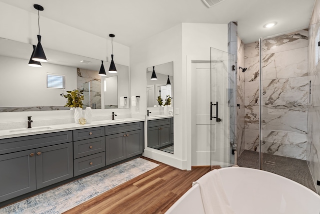 bathroom with wood-type flooring, independent shower and bath, and vanity