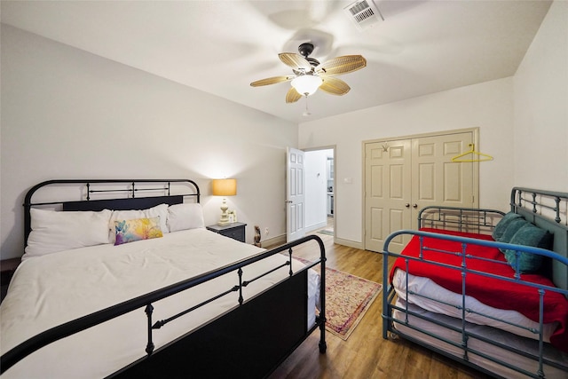 bedroom featuring ceiling fan, dark hardwood / wood-style flooring, and a closet