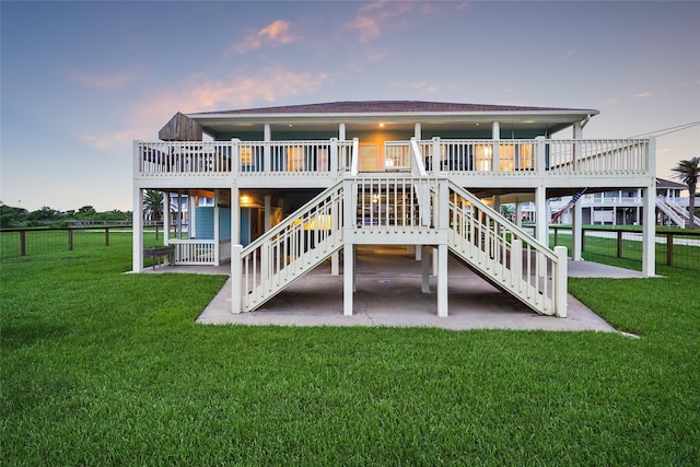 back house at dusk with a yard and a wooden deck