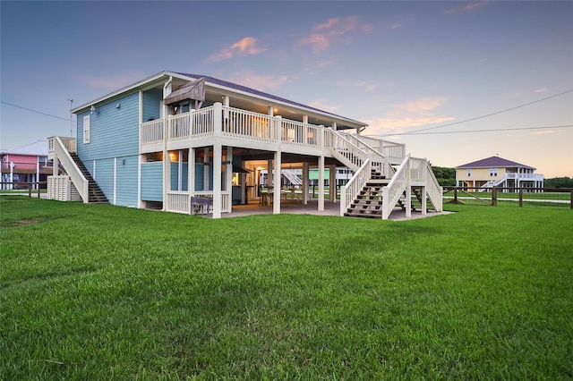 back house at dusk with a yard and a deck