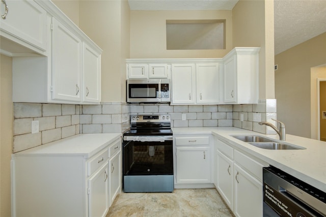 kitchen with sink, white cabinets, stainless steel appliances, and tasteful backsplash