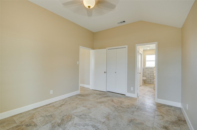 unfurnished bedroom with ceiling fan, ensuite bathroom, a closet, and vaulted ceiling