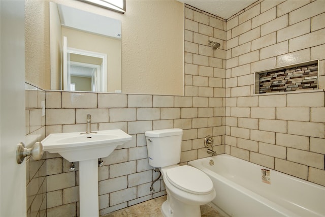 bathroom featuring toilet, tiled shower / bath, tile walls, tasteful backsplash, and a textured ceiling