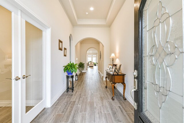 foyer featuring a raised ceiling and french doors